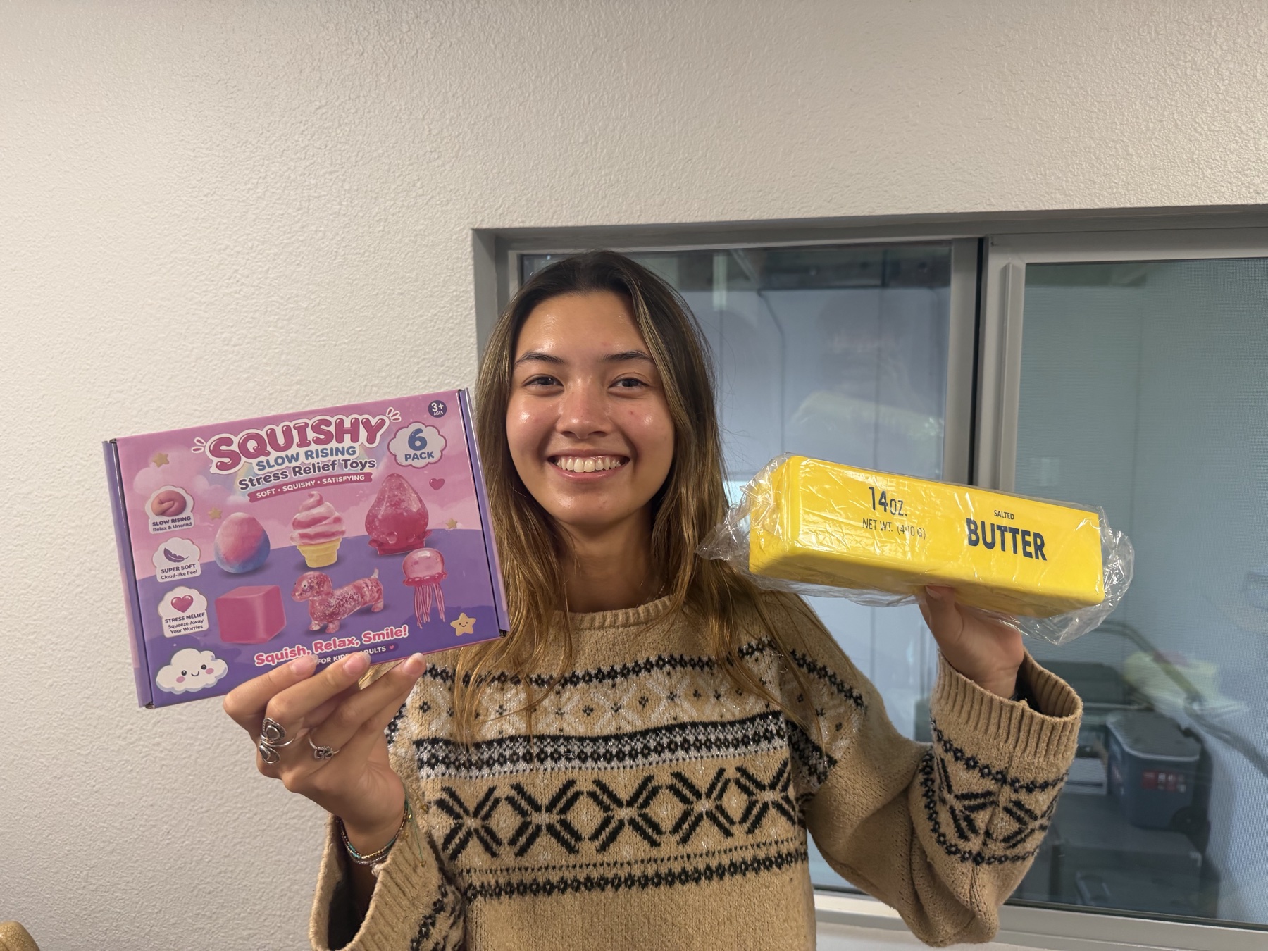 Cheyenne holding a 6-pack of slow-rising squishies and a butter squishy